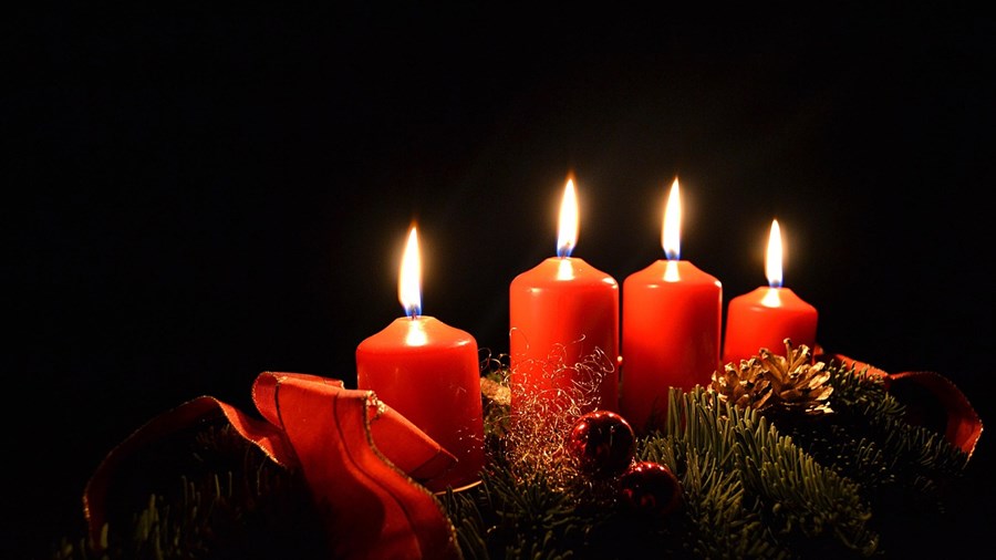 Fire røde adventslys mot sort bakgrunn.