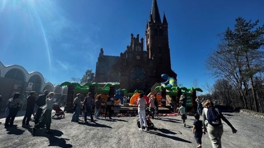 Hoppeslott forran Høvik kirke. Barn og familier som koser seg.
