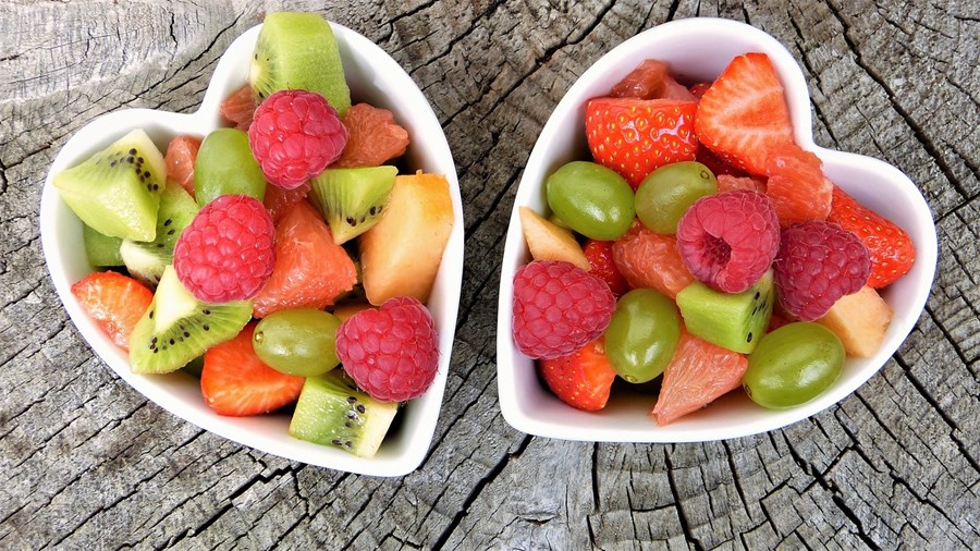 To hjerteformede skåler med frukt i mange farger