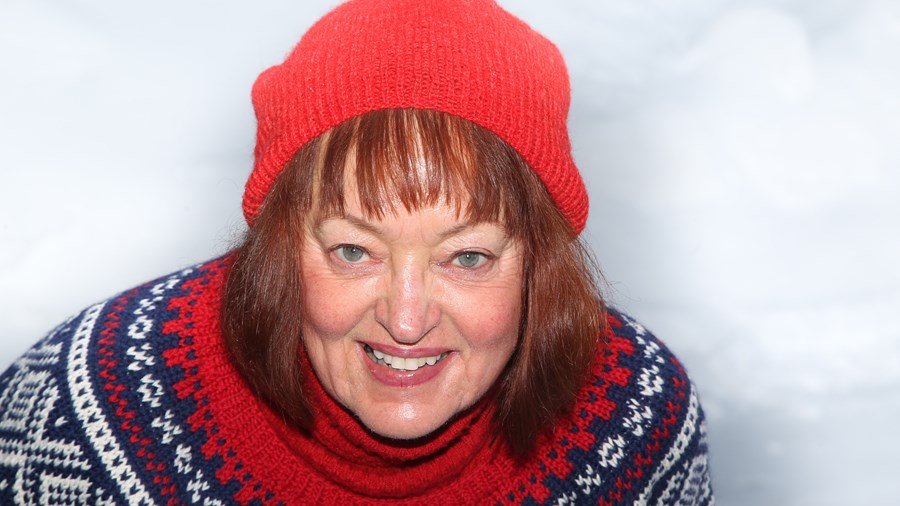 Kvinne med strikket genser og rød lue